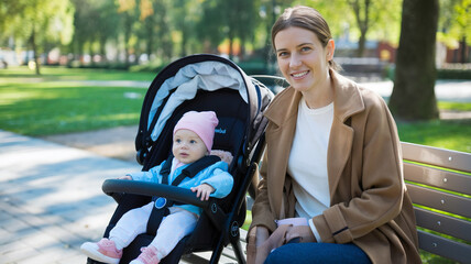 Naklejka premium Mother and Baby Enjoying a Sunny Day in the Park