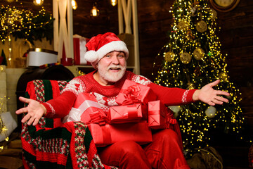 Pleased with choice. happy new year at home. presents from santa with love. winter holiday shopping. party celebration. stack gifts under Christmas tree. happy man with beard. xmas decoration