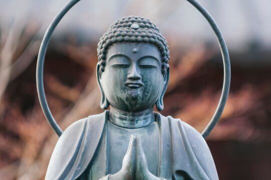 A small praying Buddah statue in close up