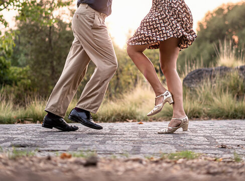 Two dancers performing elegant steps on a stone path in autumn