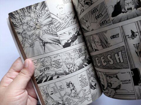 Bogor, Indonesia - October 26, 2024: A person reading Japanese comic Hitman reborn 21 written 
 by akira amano