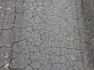 Cracks in black soil. Texture drought. Black pressed dry earth.