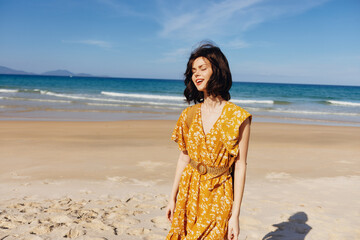 Woman enjoying a coastal sunset in a bright yellow dress with the ocean in the background