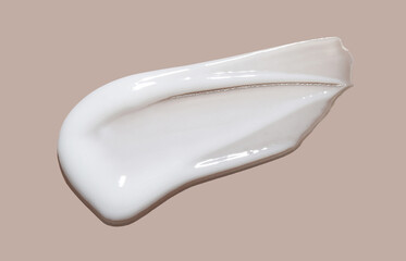 White cosmetic cream lotion swatch smear smudge on beige color background	