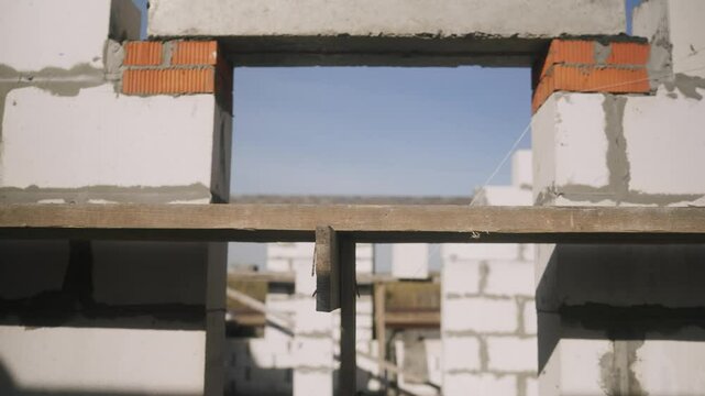 Construction workers engaged in installing a concrete lintel for a window frame.