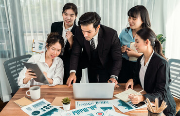 Diverse group of business analyst team analyzing financial data report paper on office table. Chart and graph dashboard by business intelligence analysis for strategic marketing planning Habiliment