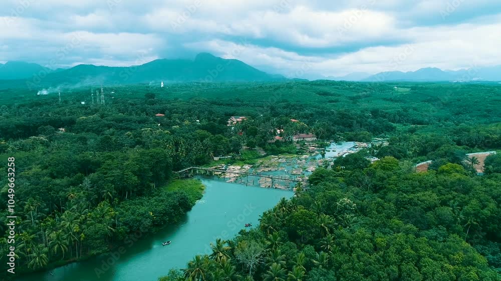 Wall mural Aerial view of river in tropical green forest with mountains in background