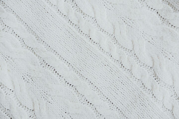 Soft white knitted fabric with textured pattern draped in natural light indoors