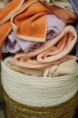 Obraz premium A Collection of Soft Towels and Blankets Neatly Piled in a Beautifully Woven Basket