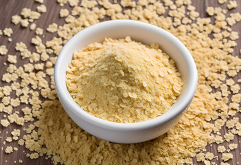 Nutritional yeast flakes, or dry inactive yeast falling background and texture.