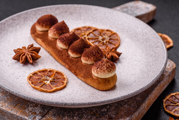 Sweet eclair with chocolate custard sprinkled with cocoa powder