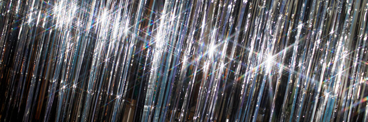Header background shot shiny silver tinsel curtain reflecting light while decorating room for Christmas celebration