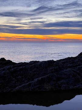 Sea, rock, sunset sky at evening.