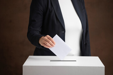 The voter holds his vote ballot paper and places it in the ballot box. Election concept.