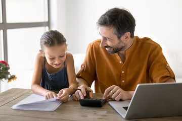 Happy middle aged Hispanic dad teaching little daughter kid to count domestic expenses at home,...