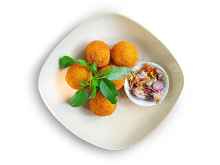 Potato balls croquettes with basil on a white background, served with Special Sambal Matah, Chili and sliced shallots.