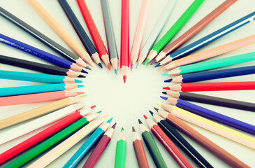 Colored pencils lying around the heart