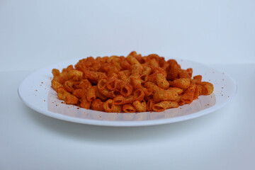 Spicy fried small macaroni crackers, on white background, isolated on white background