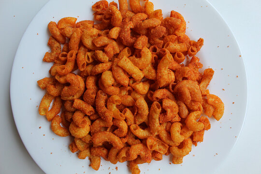 Spicy fried small macaroni crackers, on white background, isolated on white background, flat lay or top view