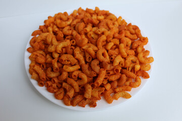 Spicy fried small macaroni crackers, on white background, isolated on white background