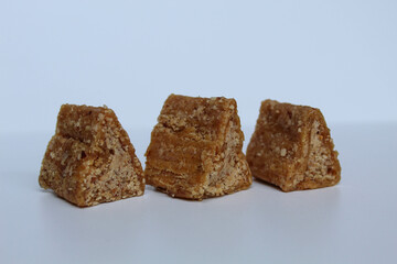 Enting-enting in triangle shape. Enting-enting is crushed peanuts mixed with sugar, Indonesia traditional snack. Isolated on white background