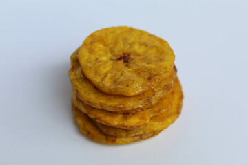 Stack of banana coin chip slices, isolated on white background