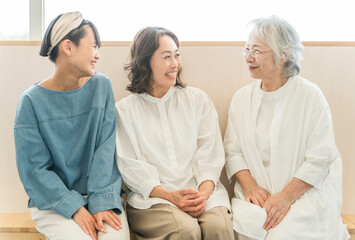 座って話をする三世代親子（孫・母親・おばあちゃん）
