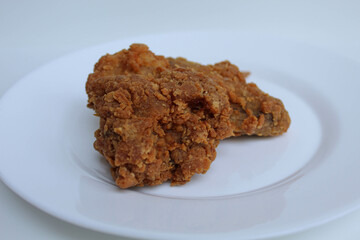 One wing crispy fried chicken, on white plate, isolated in white background, side view
