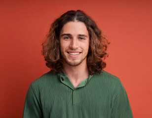 Fototapeta premium Portrait of Handsome Young Man Happily Smiling Against Colored Studio Background