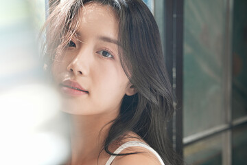 Obraz premium 自然光で撮影をした若い女性のビューティーポートレート