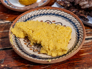Traditional polenta in a rustic plate on a wooden table.
