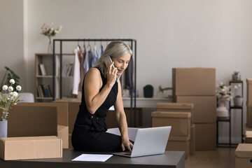 Busy older age boss online store owner take client order by phone discuss payment or delivery...