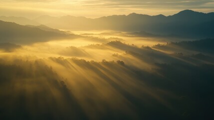 Aerial view of Betong misty mountains at sunrise, with golden light breaking through