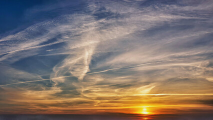 Sunset with vivid sky colors casting a warm golden glow on the horizon in the evening hours