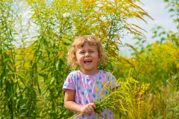 Child in ragweed flowers allergy. Selective focus.