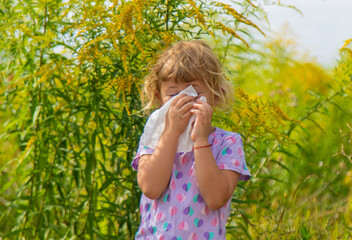 Child in ragweed flowers allergy. Selective focus.