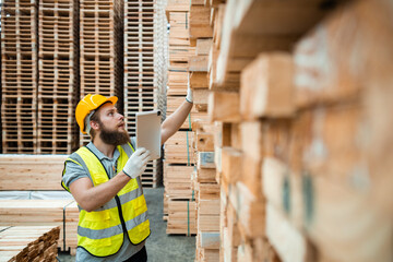 Worker Man with a bearded wearing safety uniform hard hat holding tablet working checking quality...