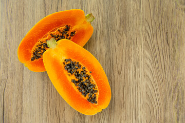 Papaya fruit on light wooden background. Slices of sweet papaya, Halved papayas