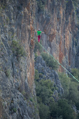 Obraz premium A tightrope walker walks along a cable stretched over a canyon.