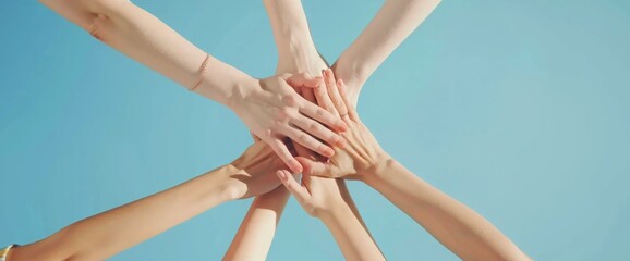 Close-up of hands put together in a gesture of team support and unity on a blue background. Conceptual image representing community, collaboration, teamwork, partnership.