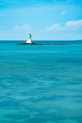 Beautiful White Lighthouse on Small Rocky Islet in Crystal Clear Turquoise Sea