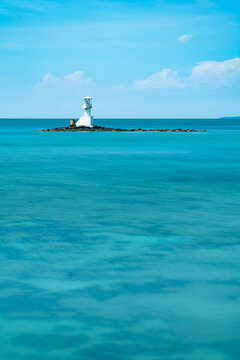Beautiful White Lighthouse on Small Rocky Islet in Crystal Clear Turquoise Sea