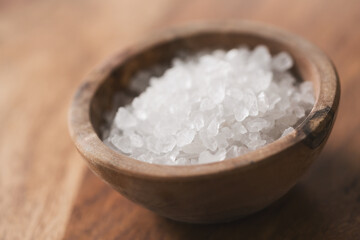 Sea salt in bowl on wood table