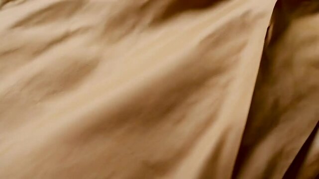 A close-up of textured brown paper, showcasing folds and smooth surfaces for crafting or packaging.