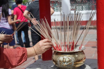 a prayer is putting joysticks in a temple