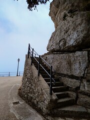Ancient stairway to Erice castle. Stairs made of stone. Medival architecture. Historical city in sky. Town in Sicily surrounded by clouds. Foggy weather in summer. Italian travel destination.