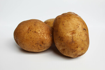 Fototapeta premium Three potatoes unpeeled, isolated on white background