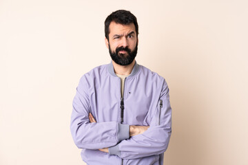 Fototapeta premium Caucasian man with beard wearing a jacket over isolated background feeling upset