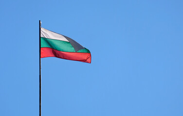 The national flag of Bulgaria in the wind against a blue sky