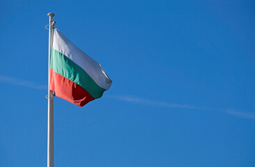The national flag of Bulgaria in the wind against a blue sky